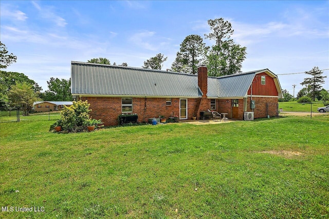 rear view of property with a yard