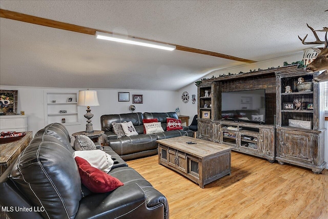 living room with hardwood / wood-style flooring, a textured ceiling, and lofted ceiling