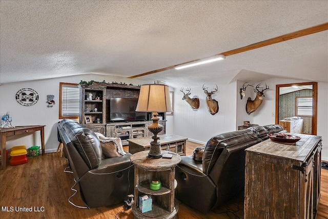 living room featuring lofted ceiling, hardwood / wood-style floors, and a textured ceiling