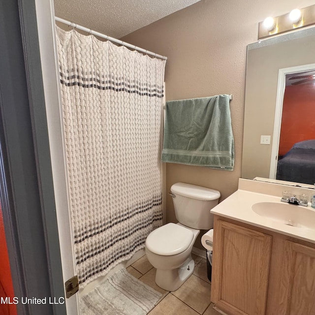 bathroom with vanity, a textured ceiling, tile patterned floors, and toilet