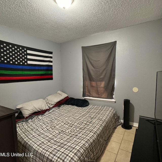 bedroom with light tile patterned floors and a textured ceiling