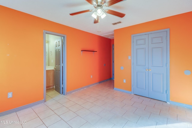 unfurnished bedroom with ensuite bathroom, ceiling fan, and light tile patterned flooring