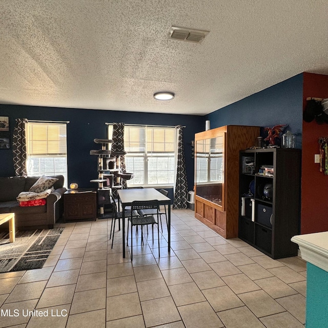 dining area featuring light tile patterned flooring and a textured ceiling