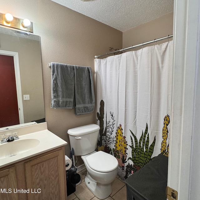 bathroom with tile patterned flooring, vanity, a textured ceiling, and toilet