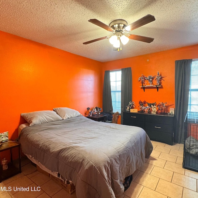 tiled bedroom featuring ceiling fan and a textured ceiling