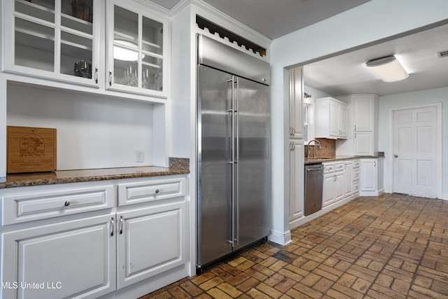 kitchen featuring sink, white cabinets, dark stone counters, and appliances with stainless steel finishes