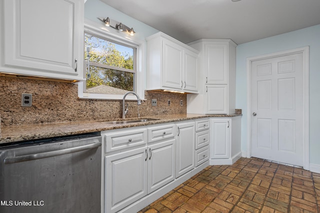 kitchen featuring backsplash, sink, white cabinets, and stainless steel dishwasher