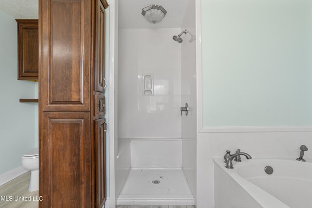 bathroom with toilet, a textured ceiling, and plus walk in shower