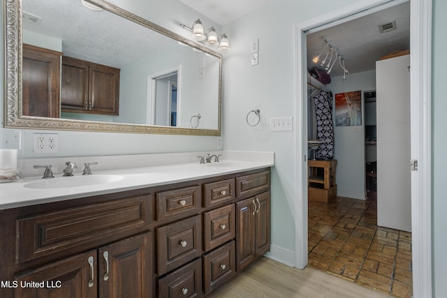 bathroom with a textured ceiling and vanity