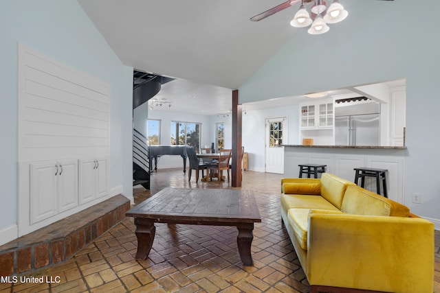 living room with ceiling fan and high vaulted ceiling