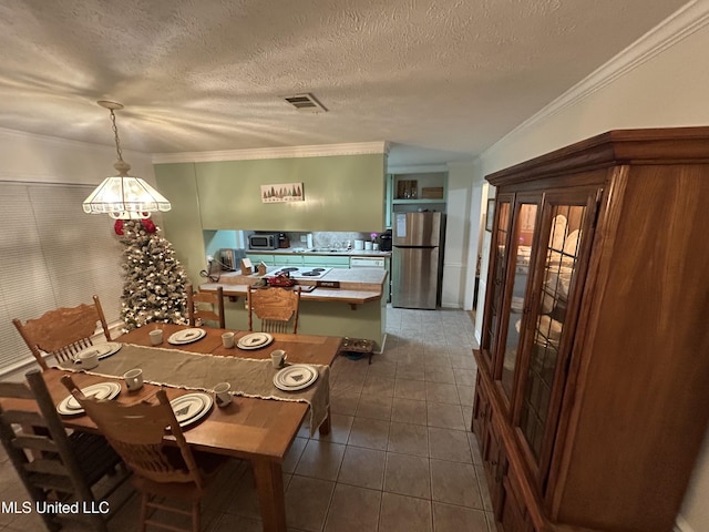 dining area featuring crown molding, dark tile patterned floors, and a textured ceiling