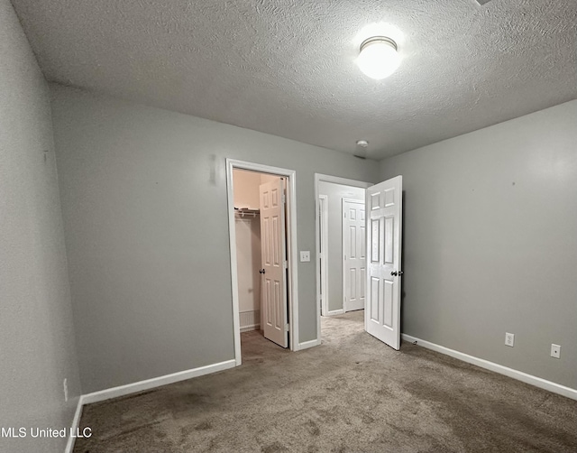 235 Gaddy Dr, Byram, MS 39272 - unfurnished bedroom featuring a walk in closet, carpet flooring, a textured ceiling, and a closet