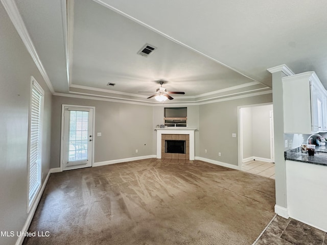 235 Gaddy Dr, Byram, MS 39272 - unfurnished living room with light colored carpet, ceiling fan, a fireplace, crown molding, and a raised ceiling