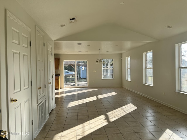 tiled empty room with plenty of natural light and lofted ceiling