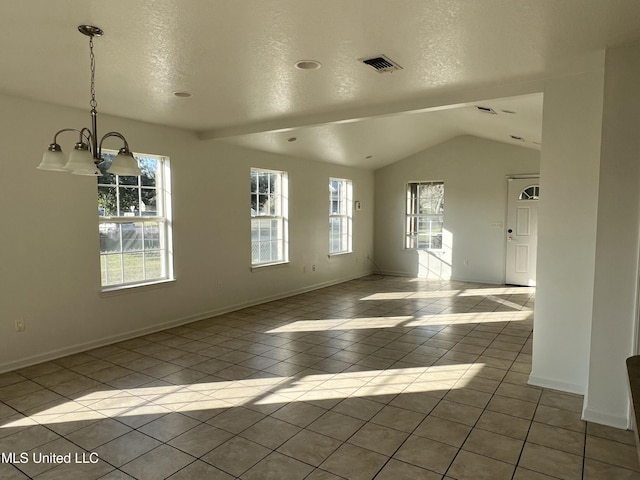 empty room with light tile patterned floors, a wealth of natural light, and vaulted ceiling