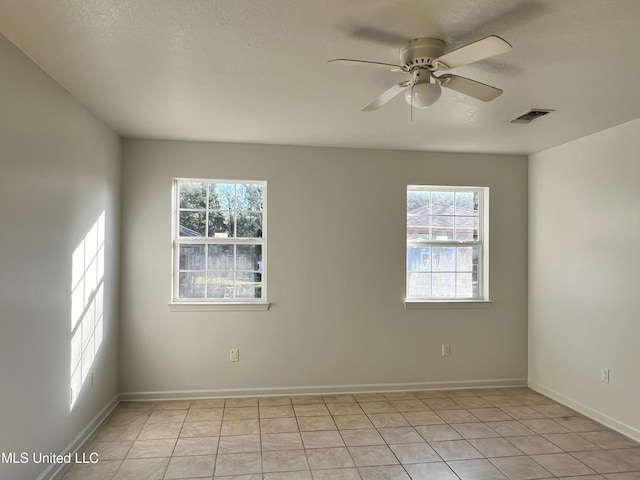 tiled spare room with ceiling fan and a healthy amount of sunlight