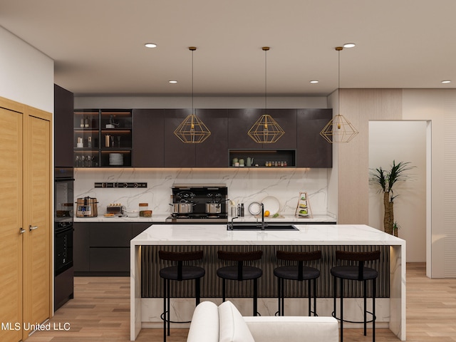 bar featuring backsplash, double oven, pendant lighting, and light wood-type flooring