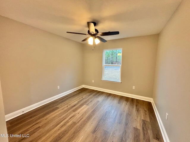 spare room with dark hardwood / wood-style floors and ceiling fan