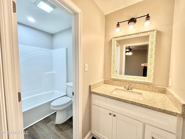 full bathroom featuring vanity, hardwood / wood-style floors, bathtub / shower combination, and toilet