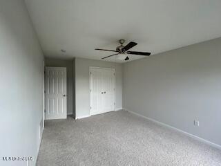 134 Shadow Ln, Batesville, MS 38606 - unfurnished bedroom with a closet, baseboards, carpet floors, and ceiling fan