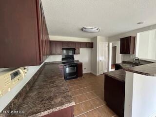 134 Shadow Ln, Batesville, MS 38606 - kitchen with a peninsula, dark tile patterned floors, dark countertops, and range