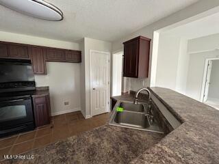 134 Shadow Ln, Batesville, MS 38606 - kitchen featuring a sink, range, baseboards, dark countertops, and dark brown cabinetry