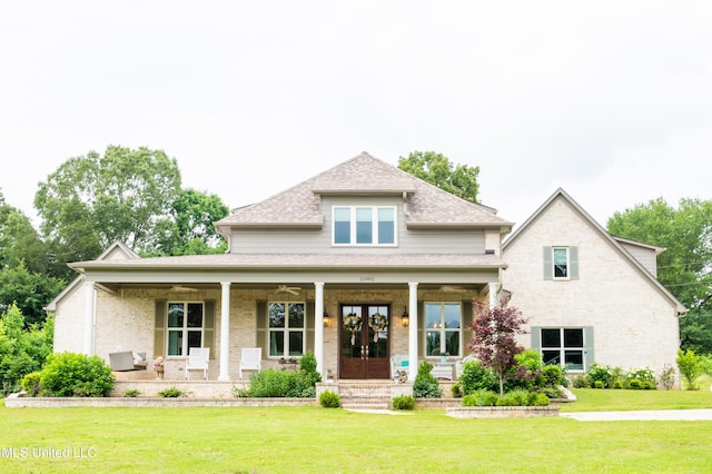 view of front of property featuring covered porch, roof with shingles, a front lawn, and french doors