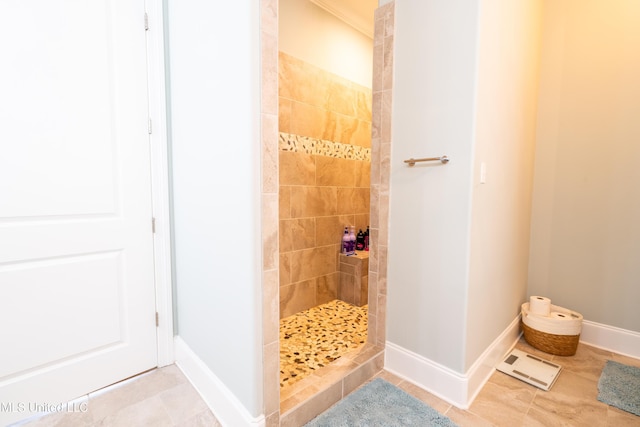 full bath with tile patterned flooring, tiled shower, and baseboards