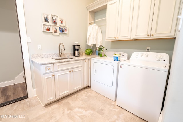 clothes washing area featuring a sink, cabinet space, and washer and dryer