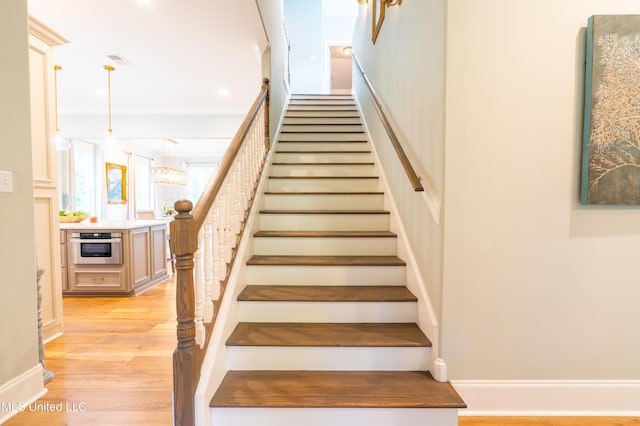 staircase featuring baseboards and wood finished floors