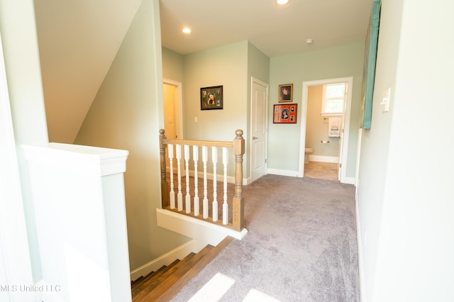 hallway featuring baseboards, carpet floors, an upstairs landing, and recessed lighting