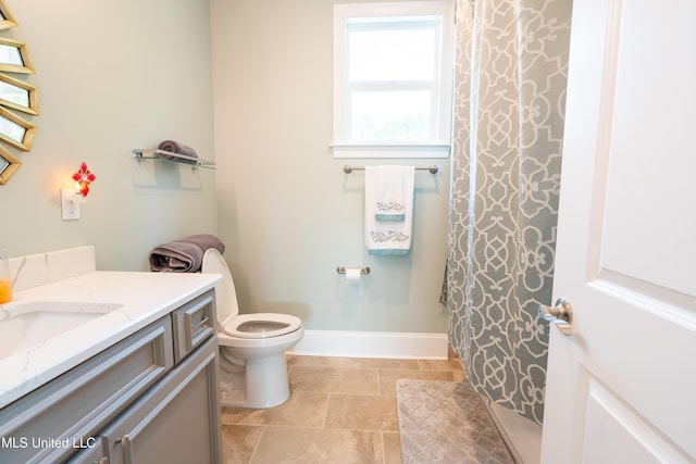 bathroom with toilet, curtained shower, baseboards, and vanity