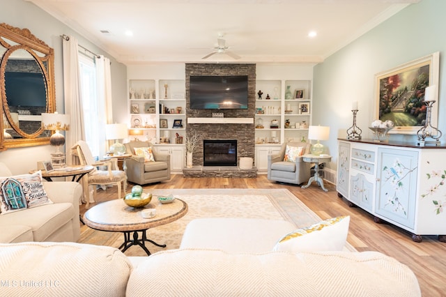 living room featuring a ceiling fan, ornamental molding, light wood-style floors, a fireplace, and recessed lighting