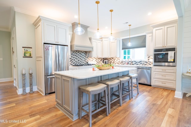 kitchen with crown molding, stainless steel appliances, backsplash, a kitchen island, and a kitchen breakfast bar