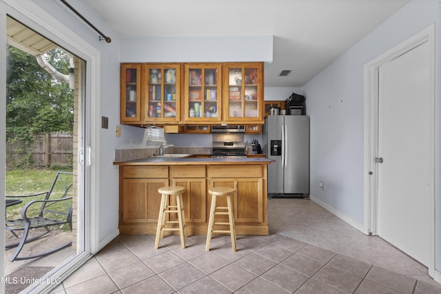 12509 Ponce De Leon Dr, Ocean Springs, MS 39564 - kitchen with glass insert cabinets, a sink, visible vents, exhaust hood, and appliances with stainless steel finishes