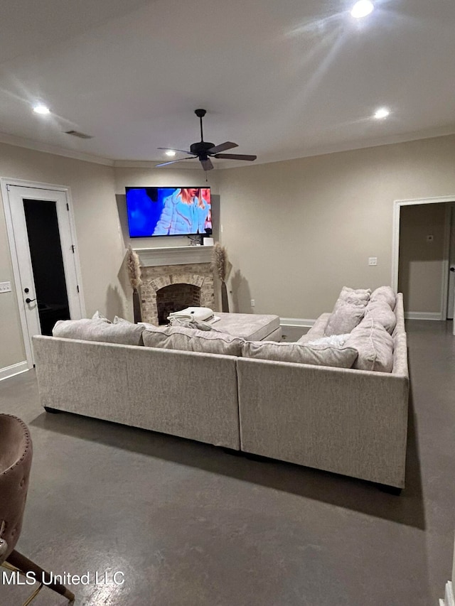 living room with ceiling fan, a stone fireplace, and ornamental molding