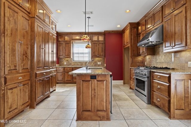 1529 Magnolia St Unit 15, Gulfport, MS 39507 - kitchen with high end range, under cabinet range hood, a sink, brown cabinets, and light stone countertops