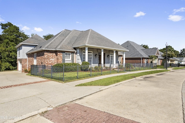 1529 Magnolia St Unit 15, Gulfport, MS 39507 - view of front facade with driveway, brick siding, a porch, a garage, and roof with shingles