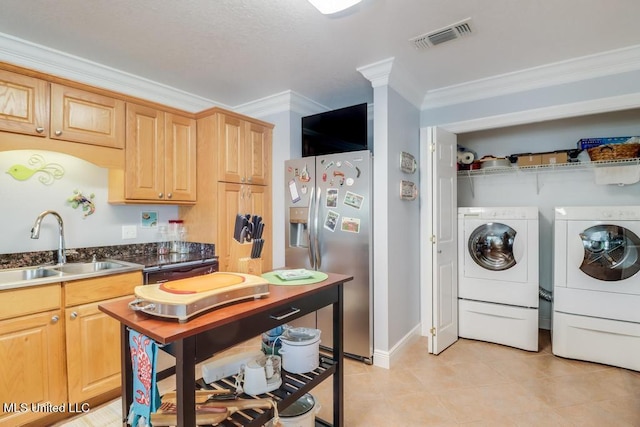 kitchen featuring sink, crown molding, stainless steel fridge, washing machine and dryer, and light brown cabinets