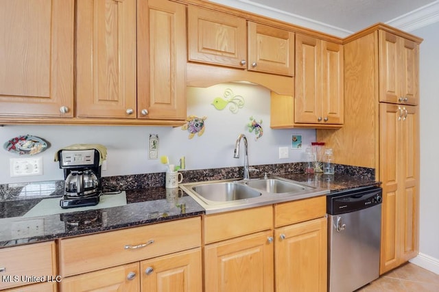 kitchen with dishwasher, sink, light tile patterned floors, and dark stone counters