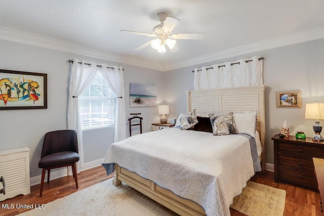 bedroom featuring crown molding, ceiling fan, and wood-type flooring