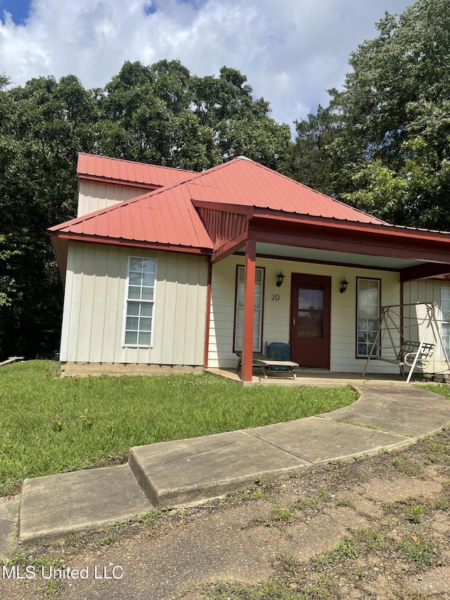 20 Cedar Hts, Pope, MS 38658 - view of front facade with a porch, board and batten siding, a front lawn, and metal roof