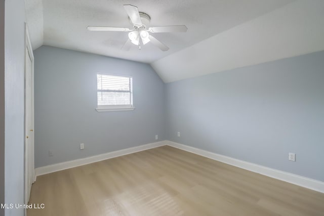 bonus room with light wood finished floors, ceiling fan, baseboards, and vaulted ceiling