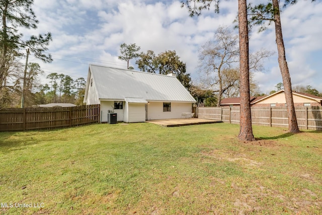 back of house with central air condition unit, a lawn, and a fenced backyard