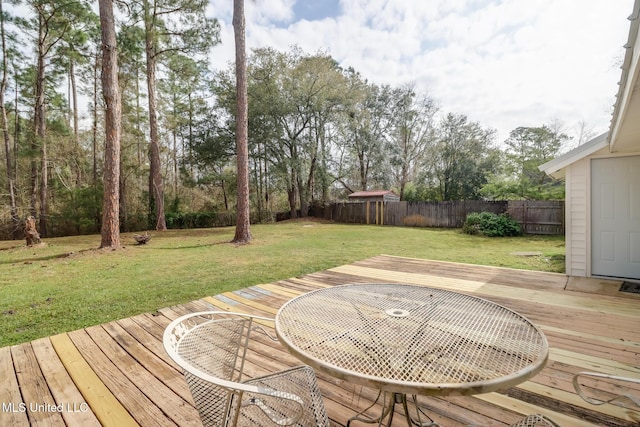 wooden terrace featuring outdoor dining area, a yard, and fence