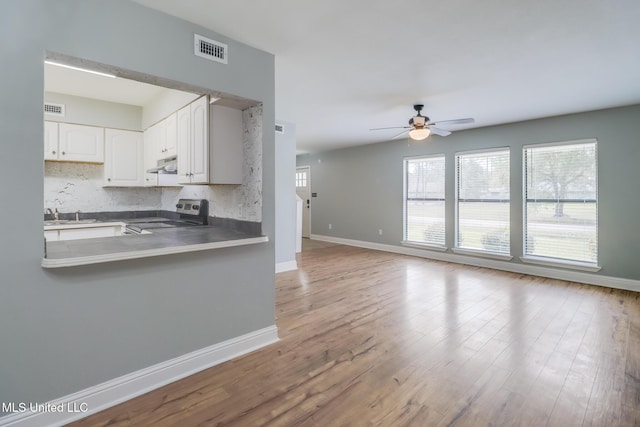 kitchen with visible vents, backsplash, ceiling fan, under cabinet range hood, and electric range