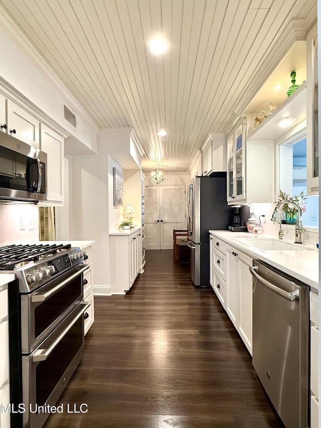 kitchen featuring appliances with stainless steel finishes, white cabinetry, wood ceiling, light countertops, and crown molding