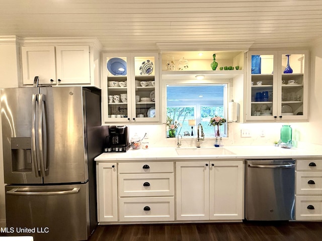 kitchen with appliances with stainless steel finishes, a sink, white cabinetry, glass insert cabinets, and wood ceiling
