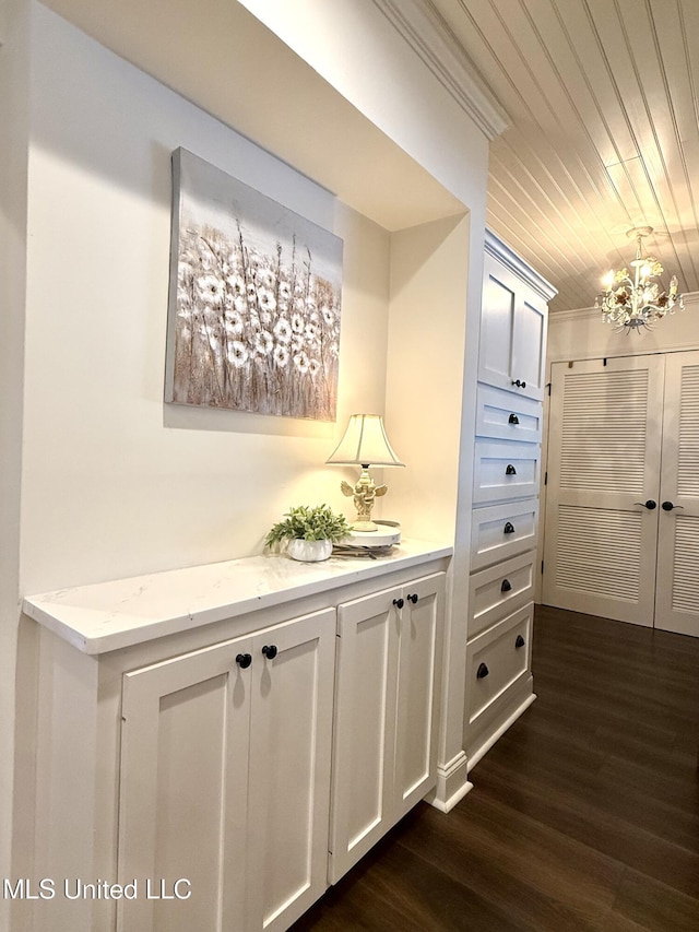 hall featuring dark wood-style flooring, a chandelier, and wooden ceiling