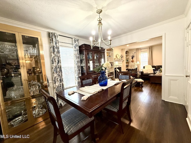dining space featuring a chandelier, dark wood-type flooring, and ornamental molding